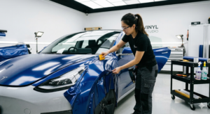 A technician applying a vinyl wrap in a clean garage.